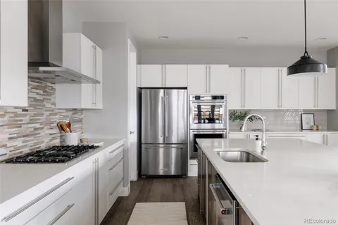 a kitchen with a sink a refrigerator and a stove top oven
