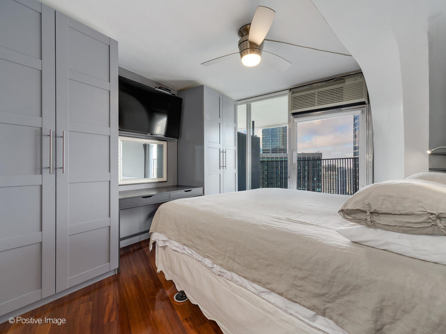 300 North State Street, Unit 5317 Chicago, IL 60654 - Photo 11 of 27 a bedroom with a bed and a chandelier