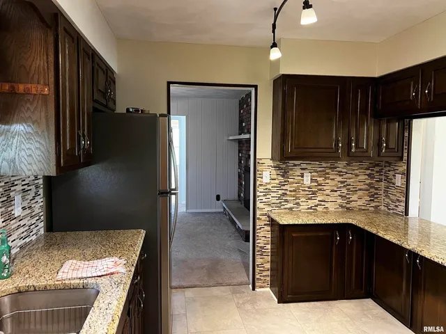 a kitchen with granite countertop a refrigerator and a stove