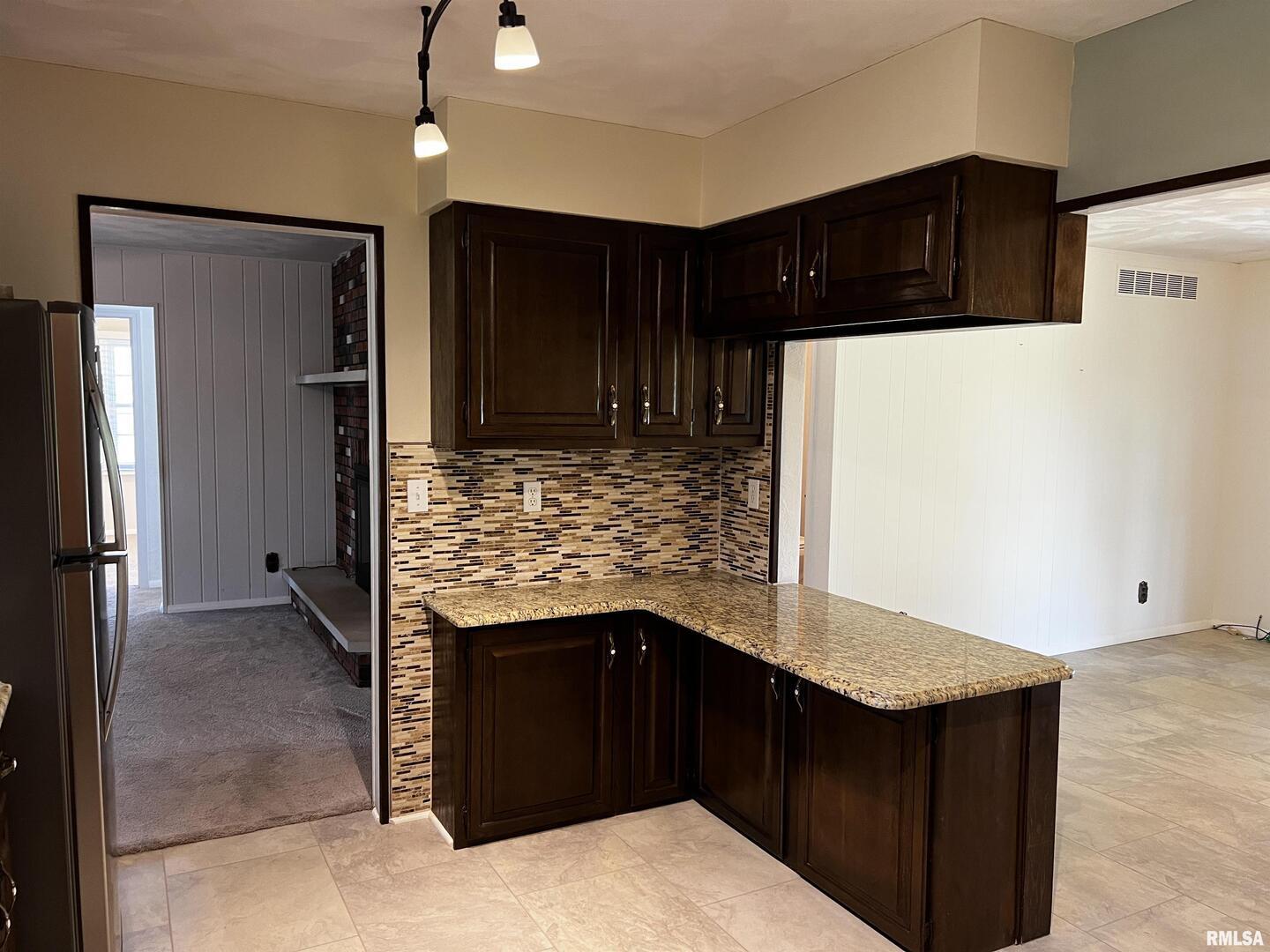 210 West Fifth Street St. Peter, IL 62880 - Photo 21 of 48 a kitchen with stainless steel appliances granite countertop wooden cabinets a refrigerator and a sink