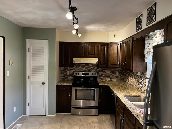 a kitchen with stainless steel appliances granite countertop a stove and a refrigerator