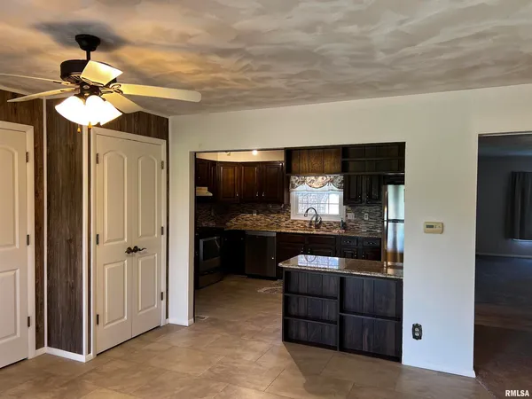 a kitchen with stainless steel appliances granite countertop a refrigerator and a stove