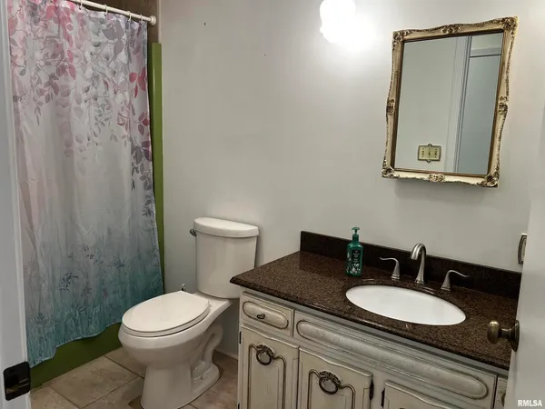 a bathroom with a toilet a sink and mirror