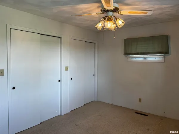 a view of a small space with wooden floor and a chandelier fan