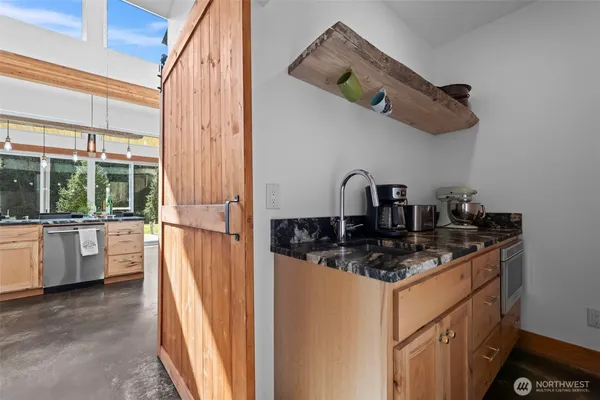a kitchen with a sink a refrigerator a window and cabinets
