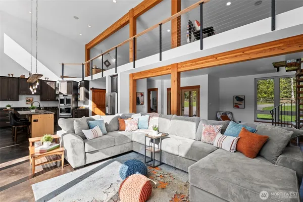 a living room with furniture kitchen view and a large window