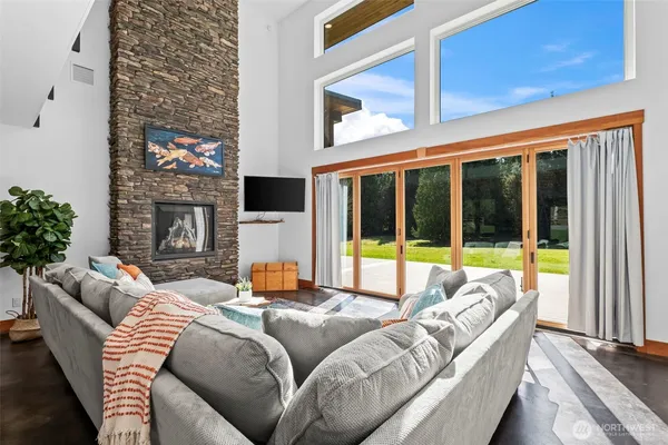 a living room with fireplace furniture and a large window