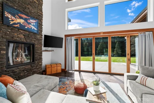 a living room with furniture a flat screen tv and a floor to ceiling window