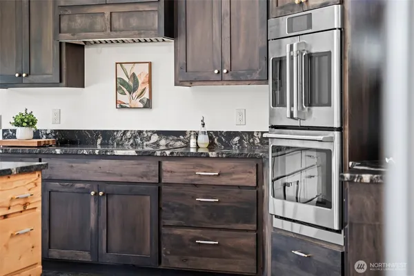 a kitchen with granite countertop a stove and a refrigerator