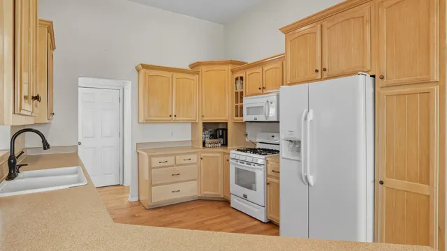 a kitchen with cabinets stainless steel appliances and wooden floor