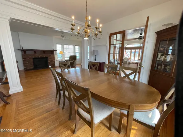 a dining room with furniture a chandelier and wooden floor