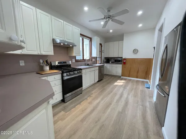 a kitchen with granite countertop a refrigerator stove top oven and sink