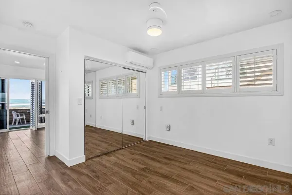 a kitchen with stainless steel appliances kitchen island granite countertop a stove top oven a sink dishwasher and white cabinets with wooden floor