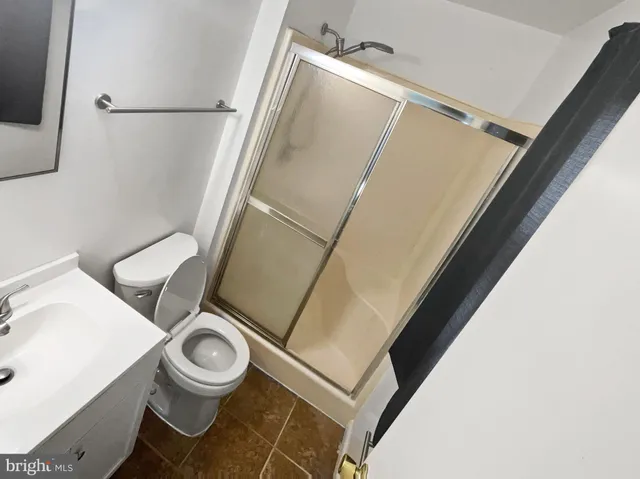 a white toilet sitting next to a white sink and vanity