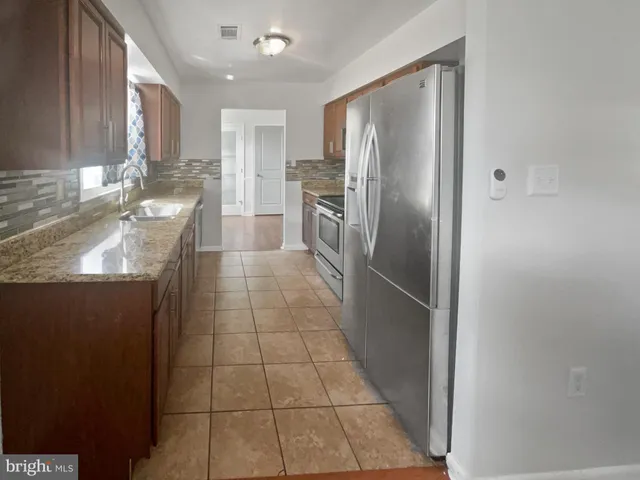 a kitchen with stainless steel appliances granite countertop a refrigerator and a sink
