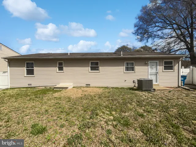 a backyard of a house with plants and wooden fence