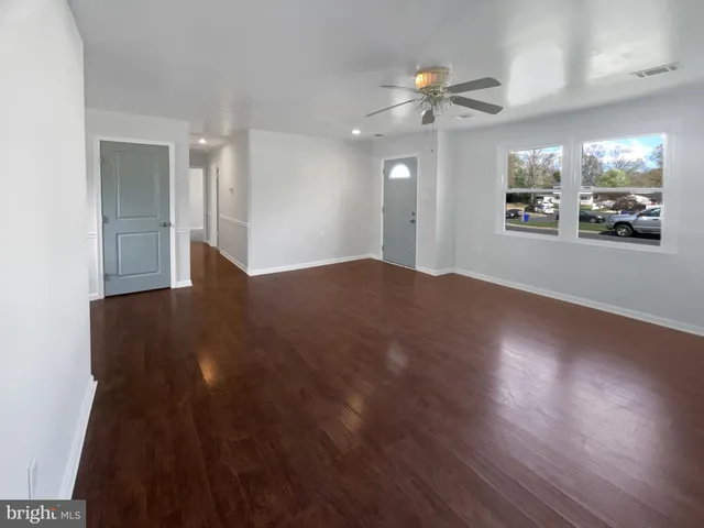 a view of a big room with wooden floor and a chandelier fan