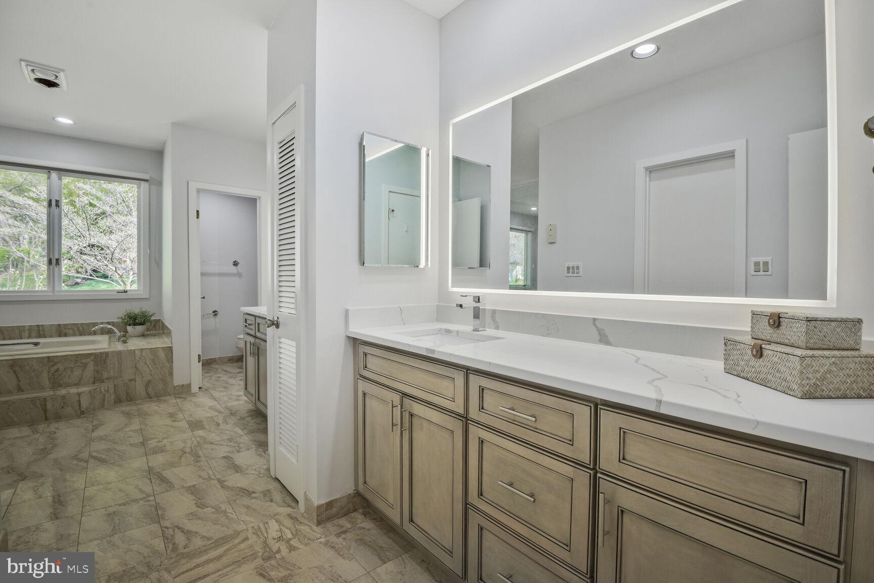 7816 Laurel Leaf Drive Potomac, MD 20854 - Photo 17 of 31 a spacious bathroom with a granite countertop sink mirror and a bathtub