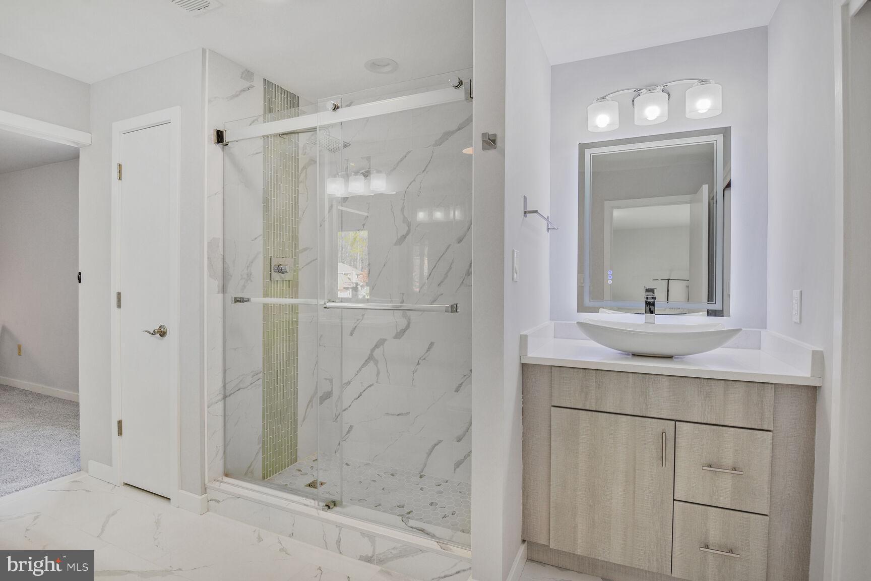 7816 Laurel Leaf Drive Potomac, MD 20854 - Photo 25 of 31 a bathroom with a shower sink and mirror