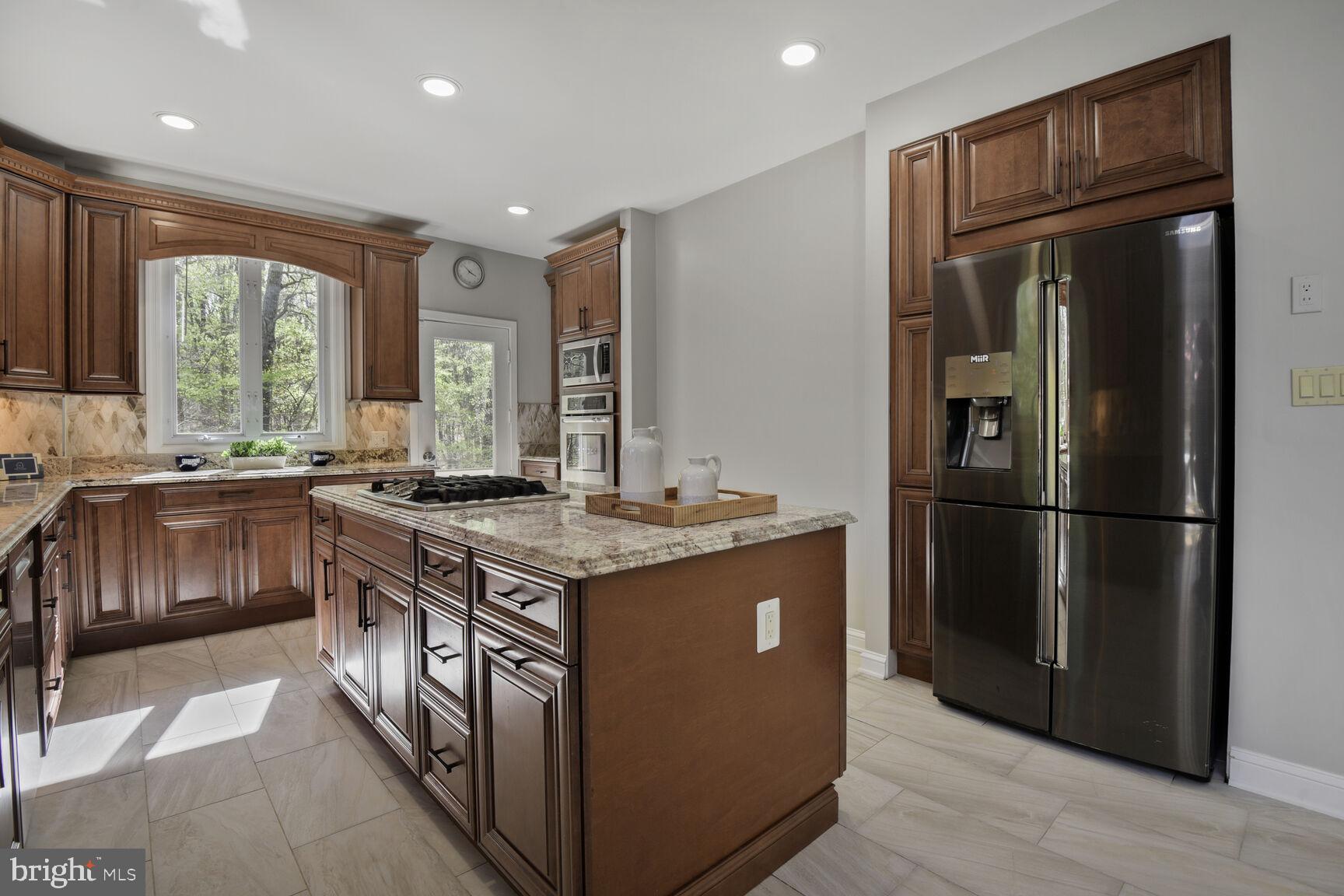 7816 Laurel Leaf Drive Potomac, MD 20854 - Photo 10 of 31 a kitchen with stainless steel appliances granite countertop a refrigerator a sink a stove and a refrigerator