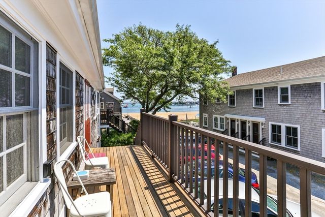 a view of deck with large trees and wooden fence