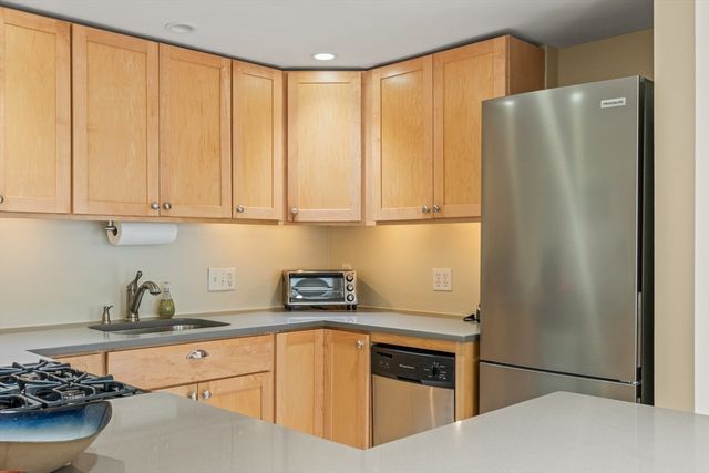 a kitchen with granite countertop stainless steel appliances a stove and a sink