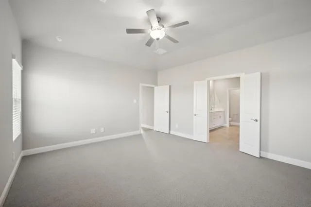 a view of an empty room with a ceiling fan