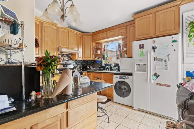 a kitchen with stainless steel appliances granite countertop a refrigerator and a sink