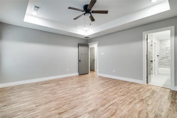 a view of a livingroom with a chandelier fan and wooden floor