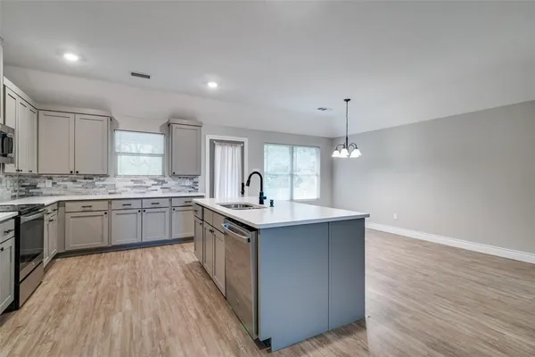 a kitchen with stainless steel appliances granite countertop a sink stove and wooden floor