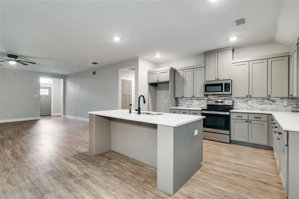 a kitchen with a sink cabinets and stainless steel appliances
