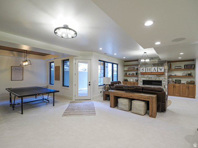 3167 South Mapleton Ests Drive Mapleton, UT 84664 - Photo 21 of 43 Spacious lower level featuring light carpeting, recessed lighting, a stone fireplace, built-in wooden shelving, and a glass-paneled door