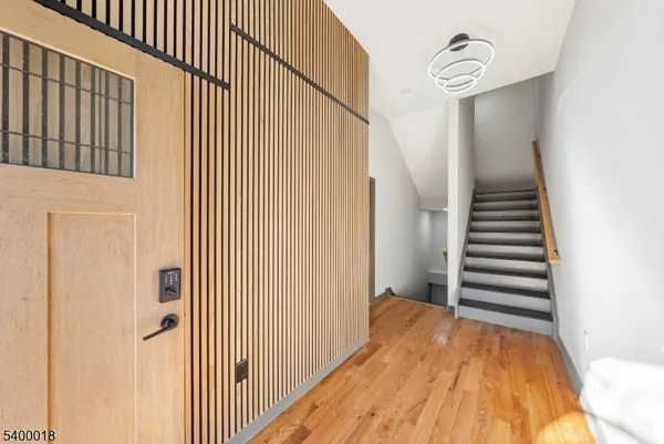 a view of a hallway with wooden floor and staircase