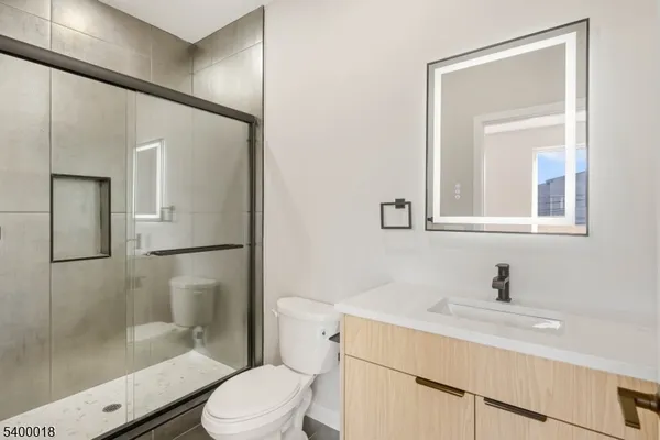 a bathroom with a sink toilet a mirror and shower