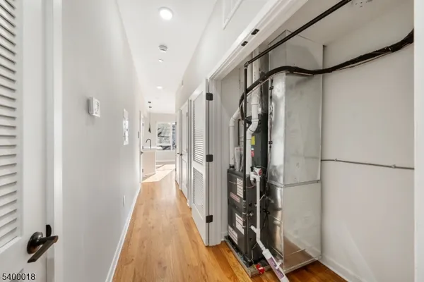 a view of a hallway with wooden floor and staircase