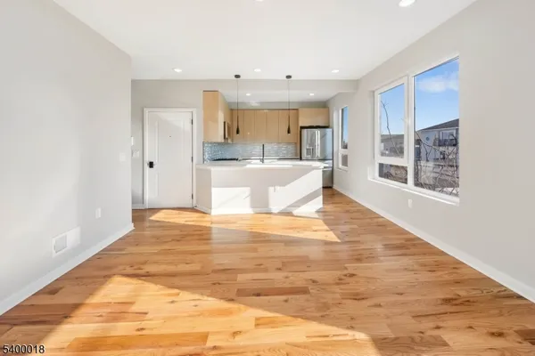 a view of a kitchen with kitchen island wooden floor and living room