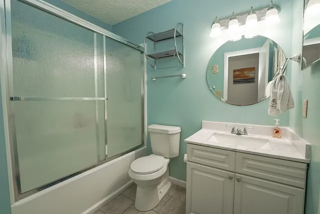 a bathroom with a sink and mirror with toilet