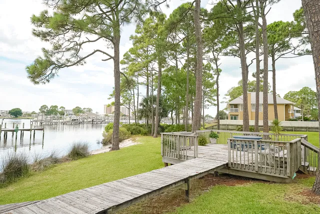 a view of a deck with a table and chairs next to a yard