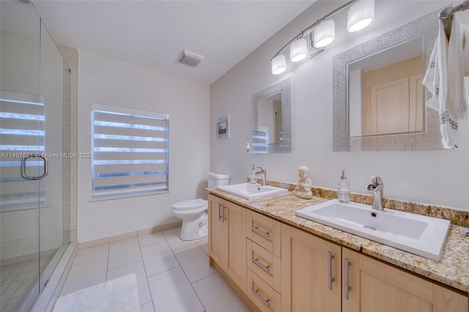 13401 Southwest 79th Street Miami, FL 33183 - Photo 20 of 34 a bathroom with a granite countertop sink a toilet and a mirror