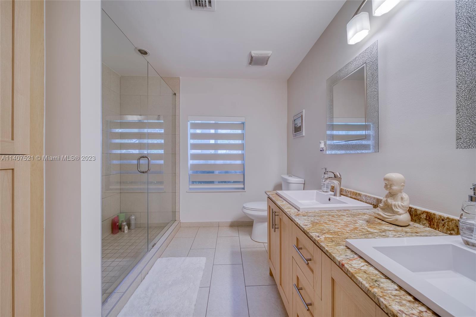 13401 Southwest 79th Street Miami, FL 33183 - Photo 21 of 34 a bathroom with a granite countertop sink a mirror and shower