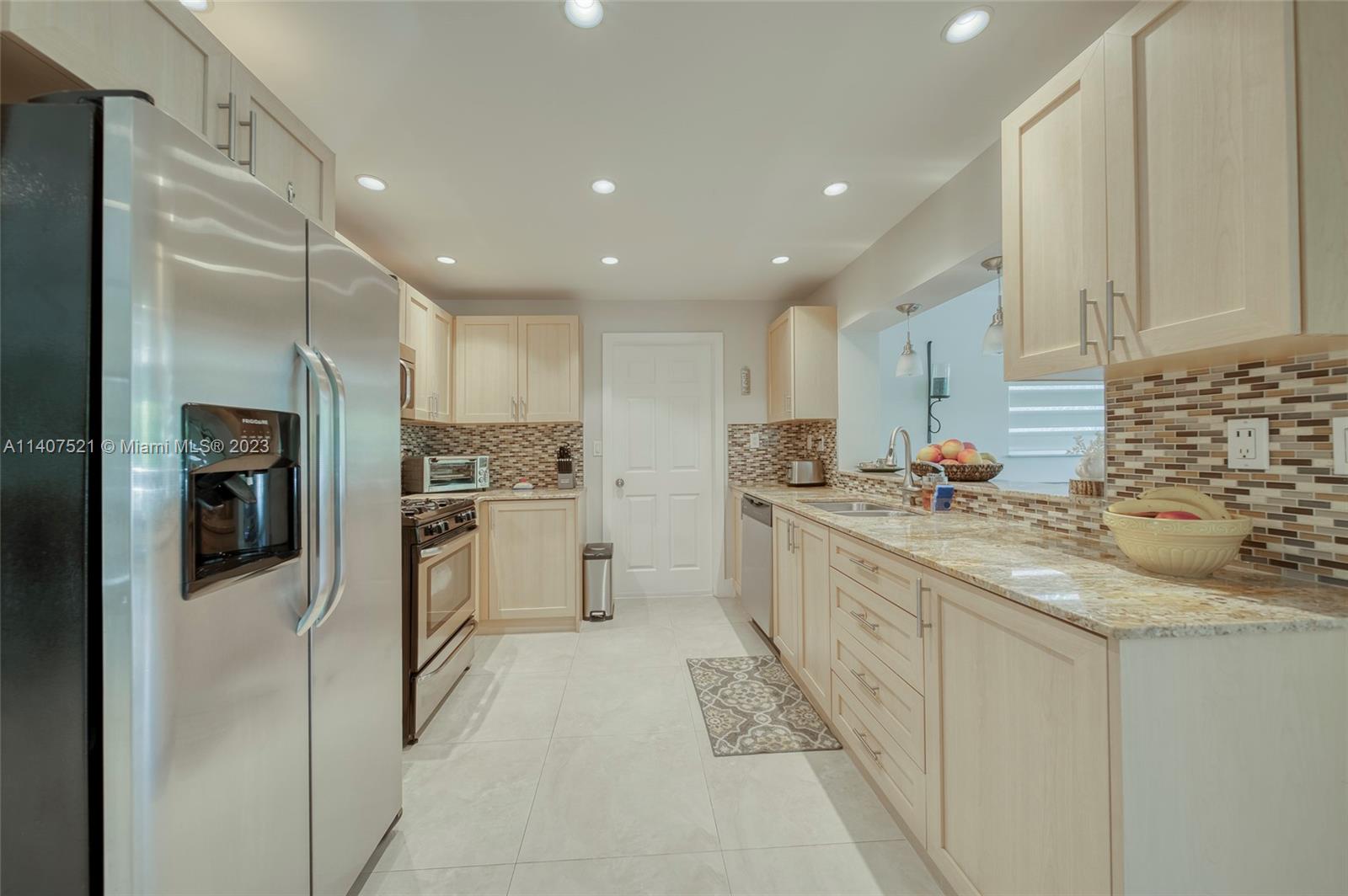 13401 Southwest 79th Street Miami, FL 33183 - Photo 7 of 34 a kitchen with granite countertop a sink stainless steel appliances and white cabinets