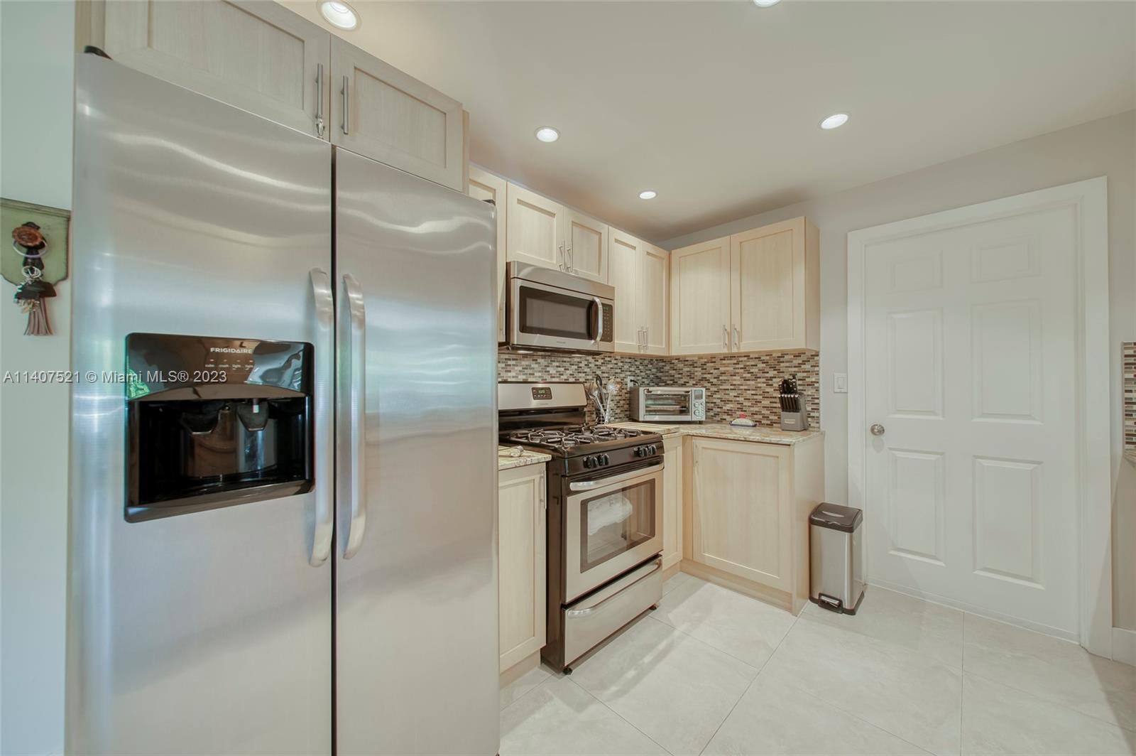 13401 Southwest 79th Street Miami, FL 33183 - Photo 8 of 34 a kitchen with stainless steel appliances granite countertop a refrigerator a stove and a sink