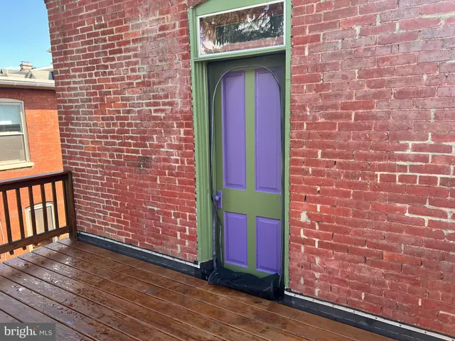 a view of front door of house with wooden stairs
