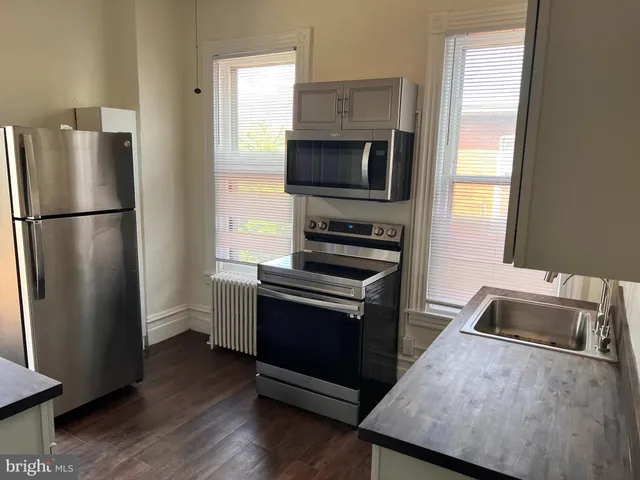 a kitchen with wooden cabinets and stainless steel appliances