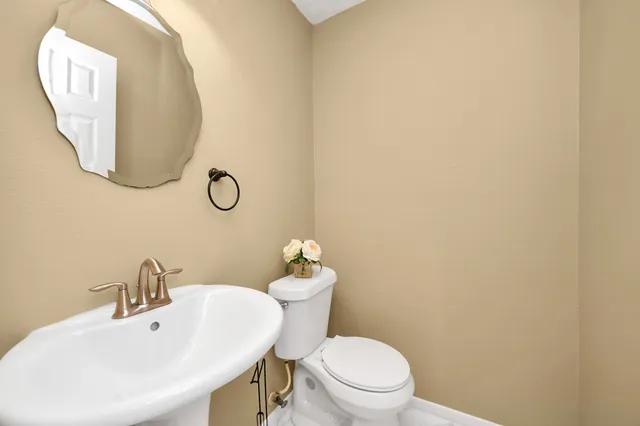 a bathroom with a sink mirror and toilet