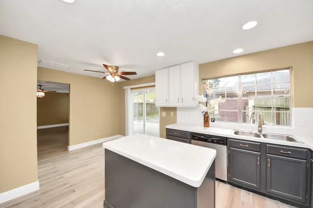 a kitchen with a sink a large window and stainless steel appliances