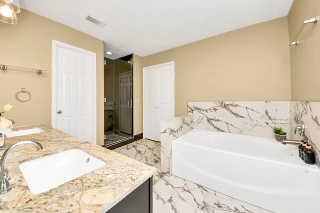a bathroom with a tub sink and mirror