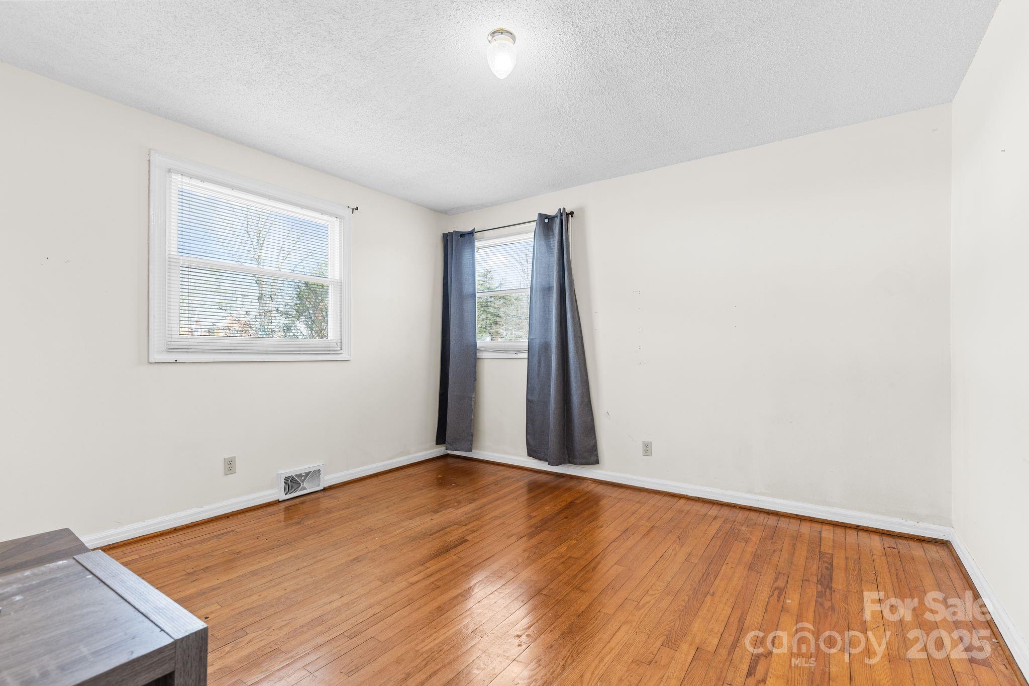 232 Hartness Road Statesville, NC 28677 - Photo 13 of 23 an empty room with wooden floor and windows