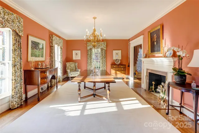 a living room with furniture a fireplace and a chandelier