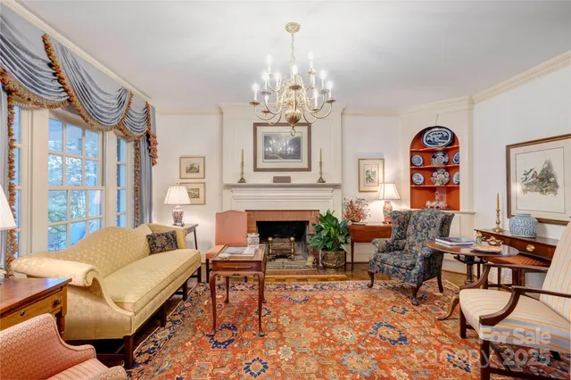 a living room with furniture a chandelier and a fireplace